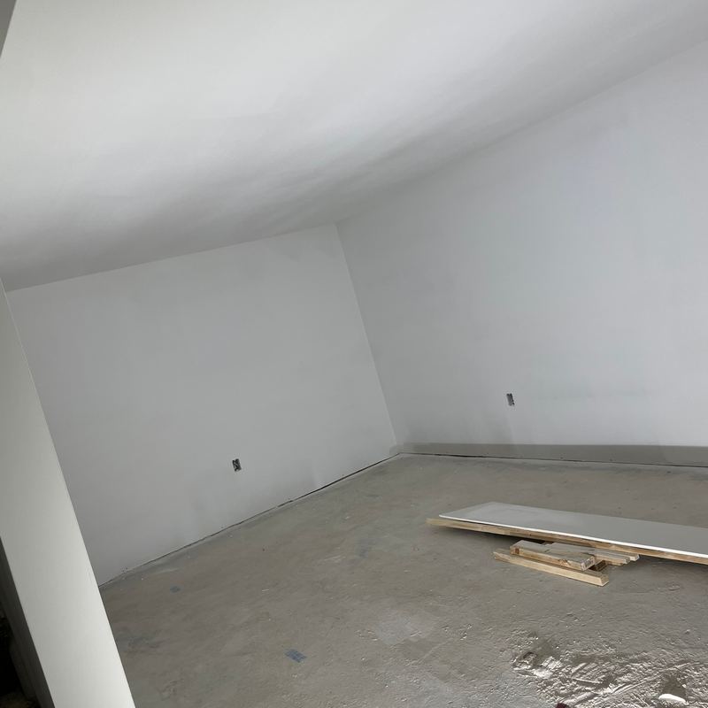 An empty new room with fresh white walls and a bare concrete floor